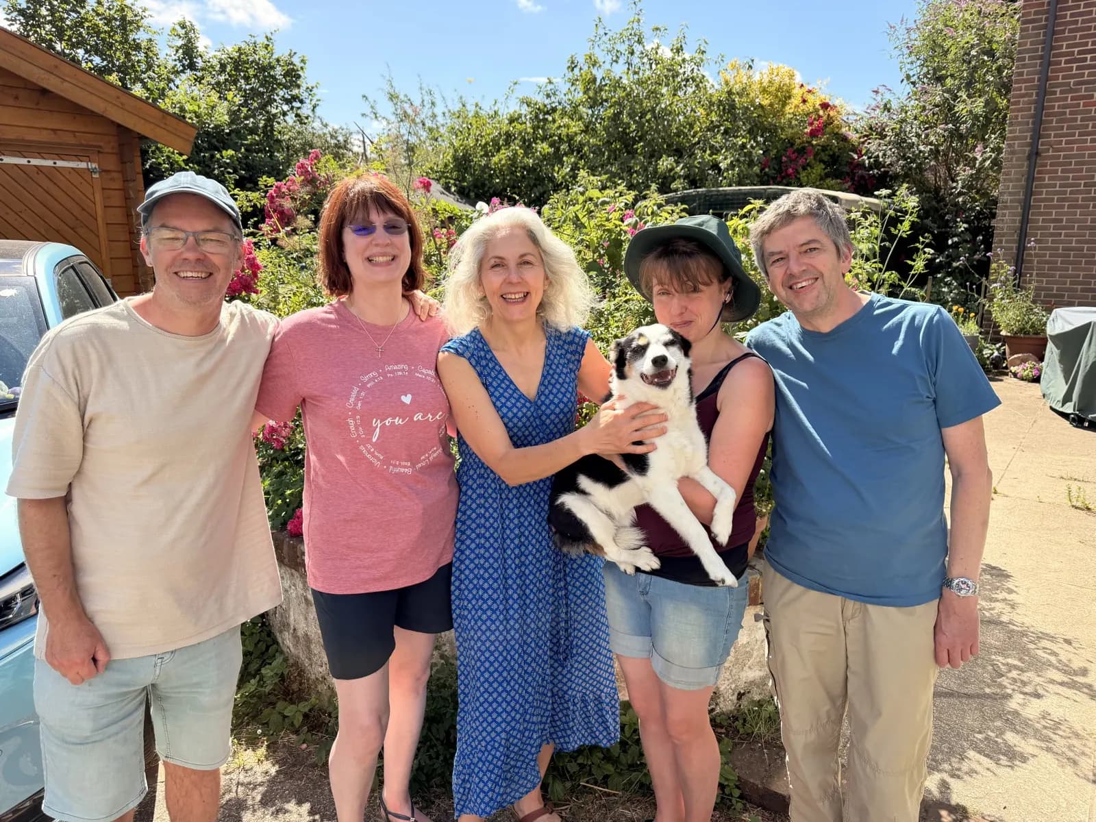 Five people and a dog outside in the sunshine before heading to the beach