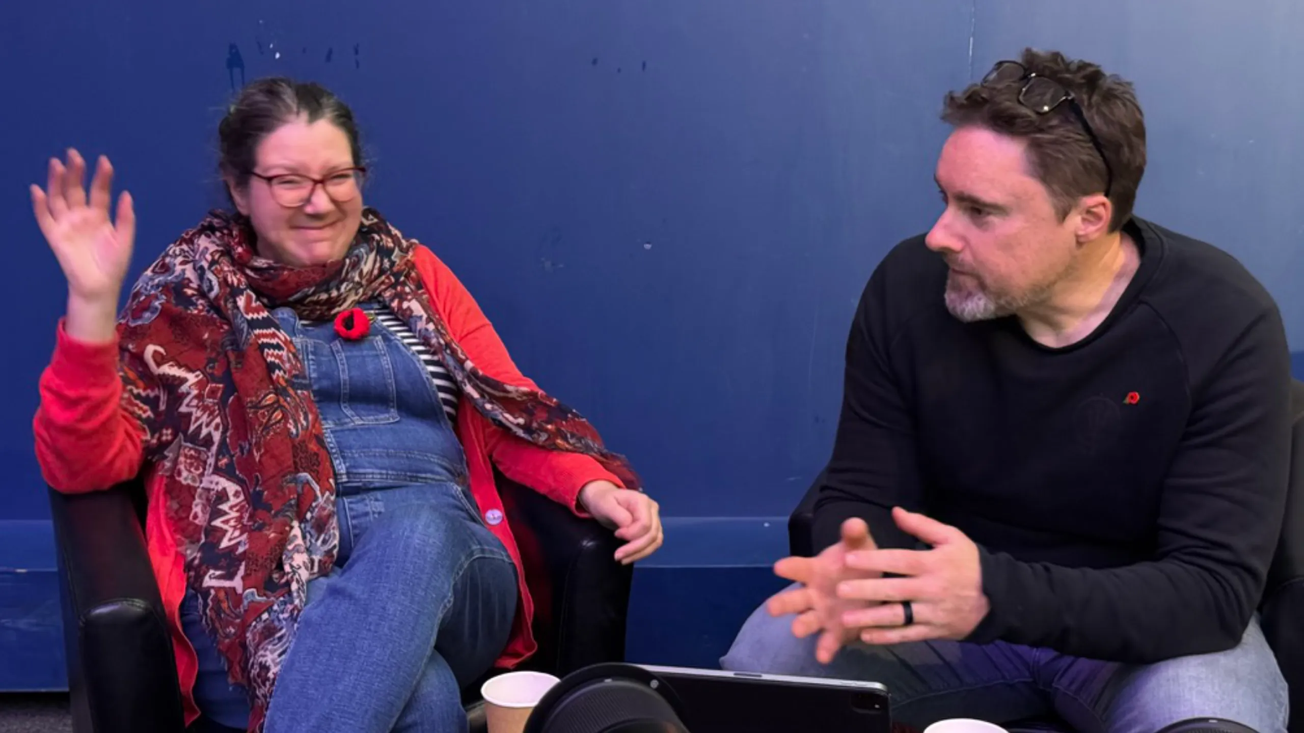 Two members of Crowd Church mid-conversation, one laughing with her hands up